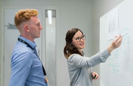 staff in front of a whiteboard
