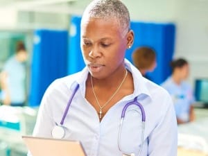 A picture of a female nurse with a clipboard at a hospital.